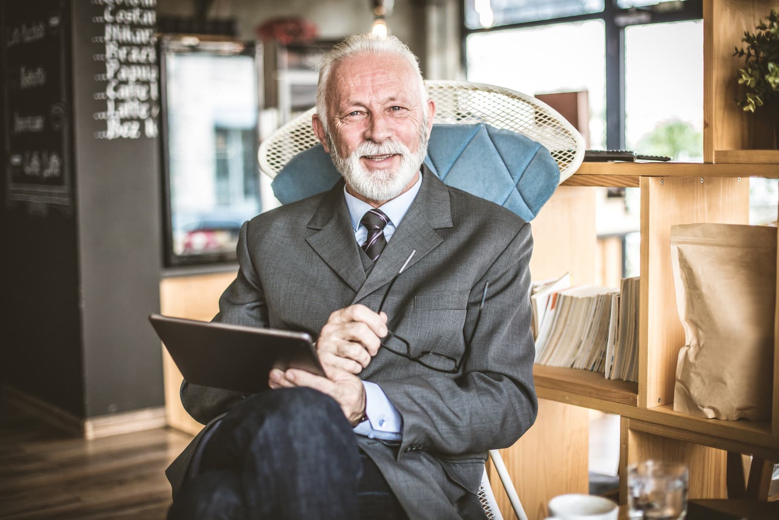 Senor businessman at bar, using digital tablet