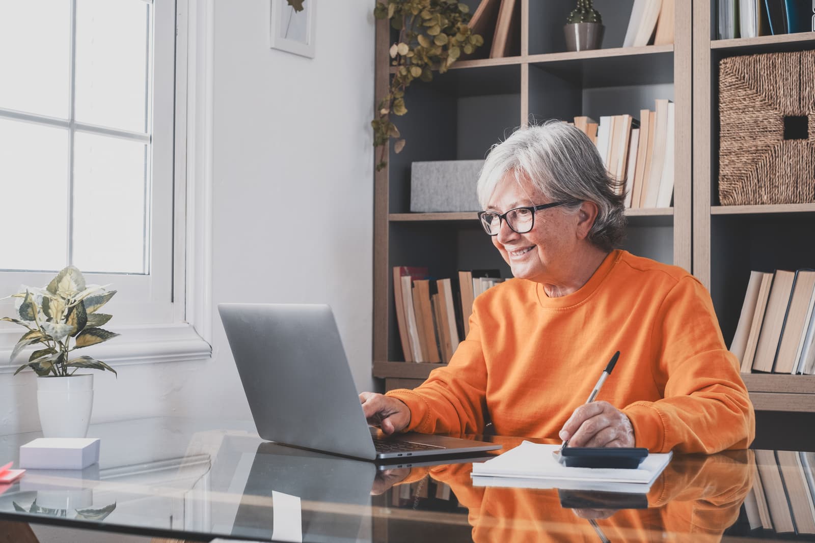 An older businesswoman making notes at her desk