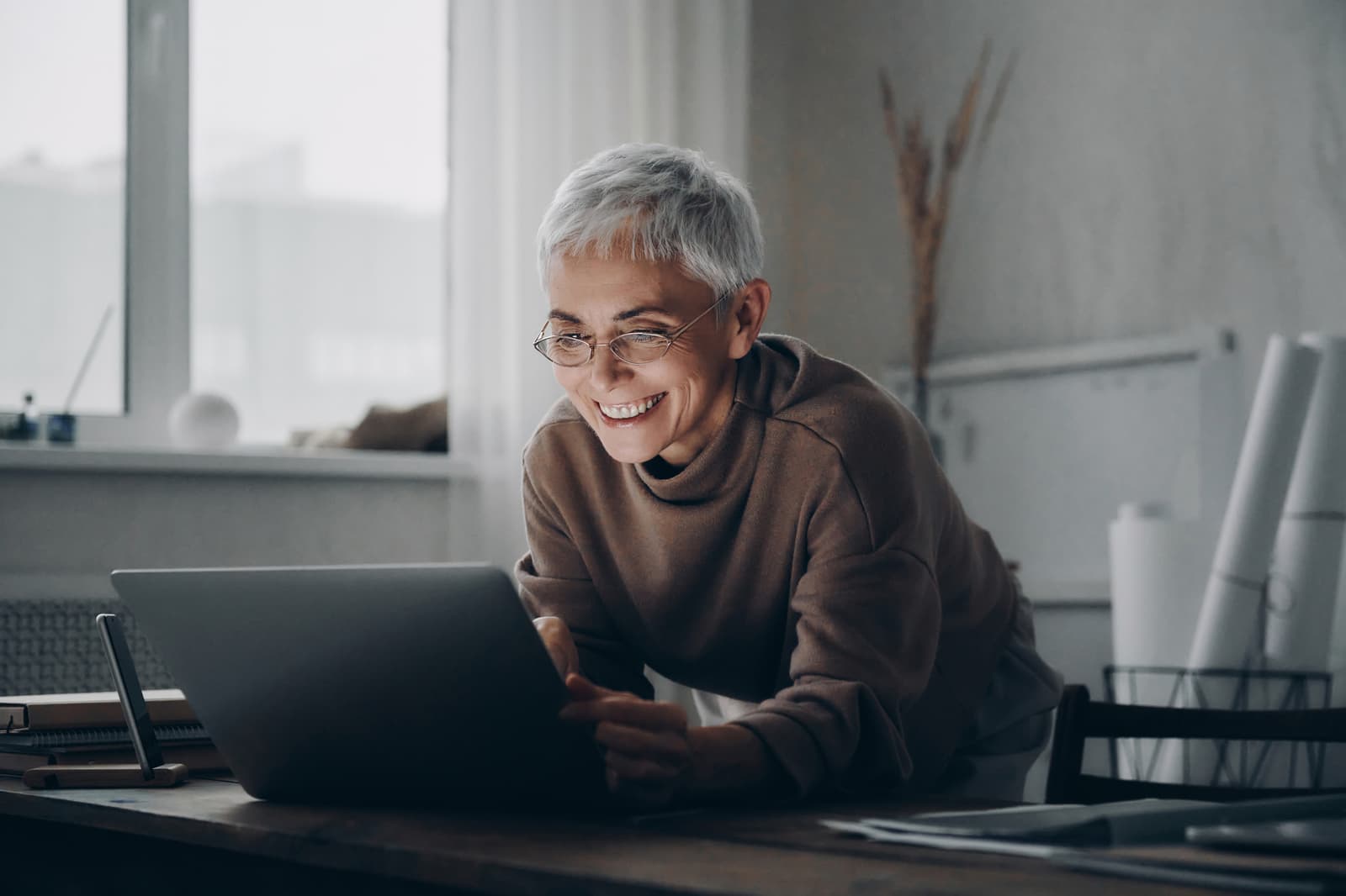 A senior woman working late at her laptop