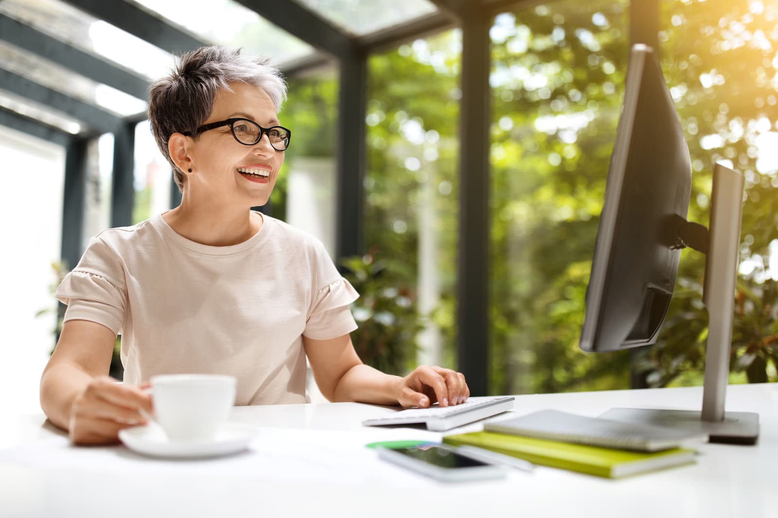 Happy mature woman employee working at coworking space