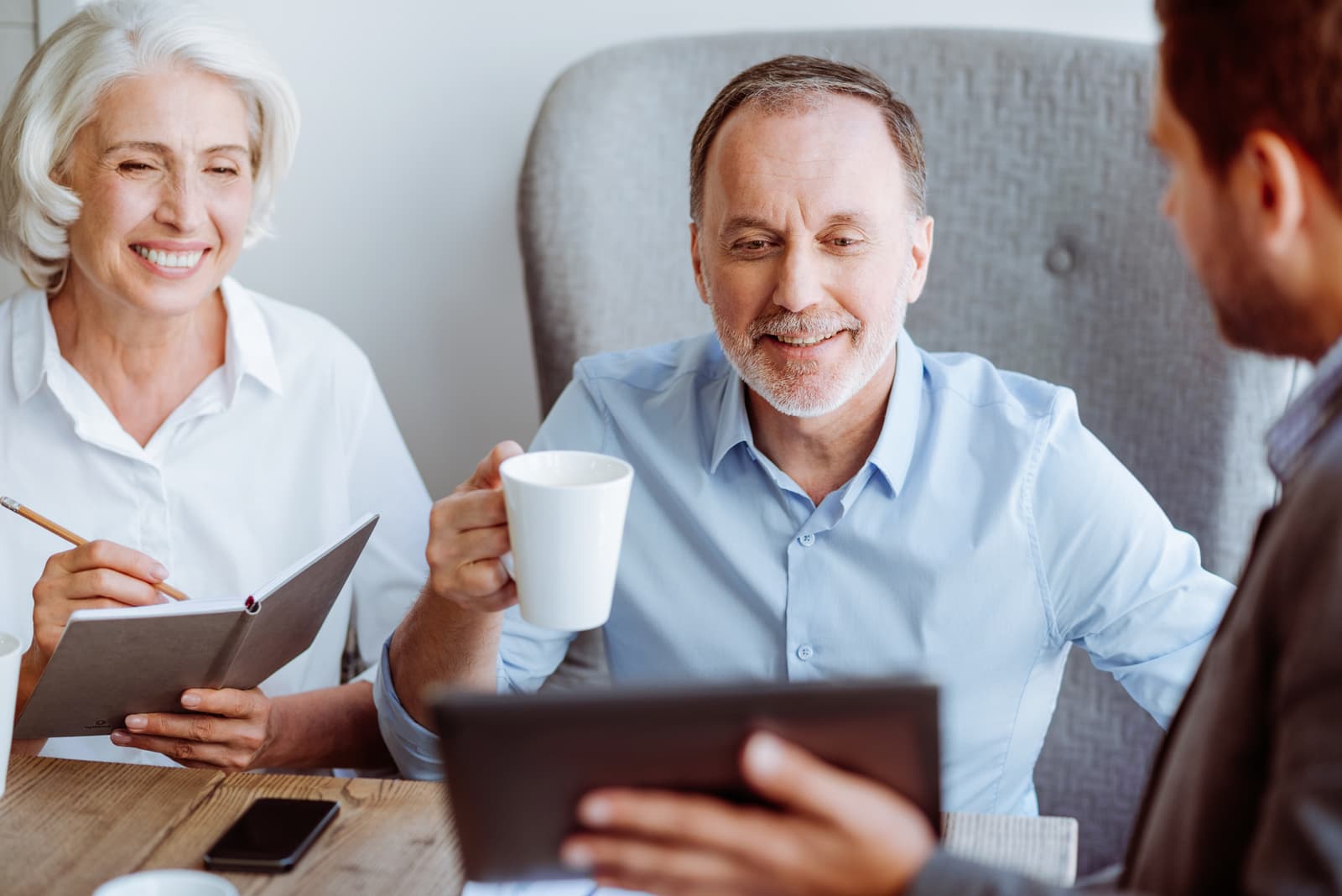 Smiling aged couple meeting with sales manager