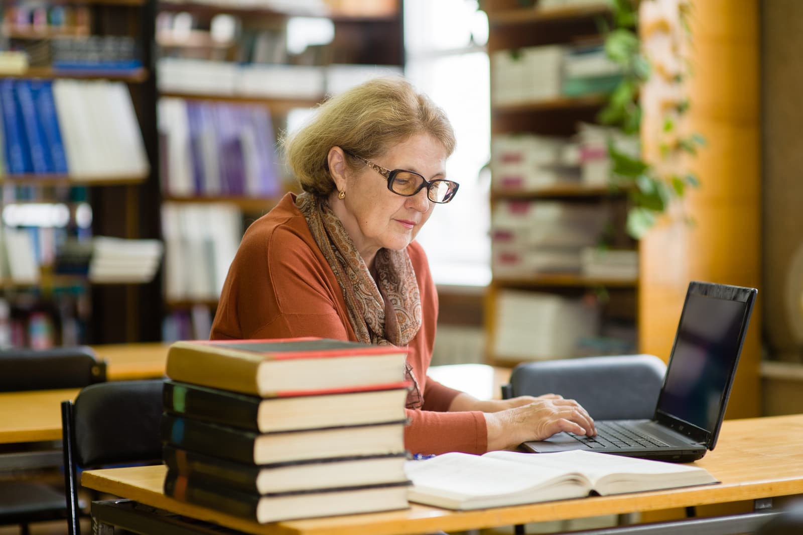 Senior woman using laptop in library