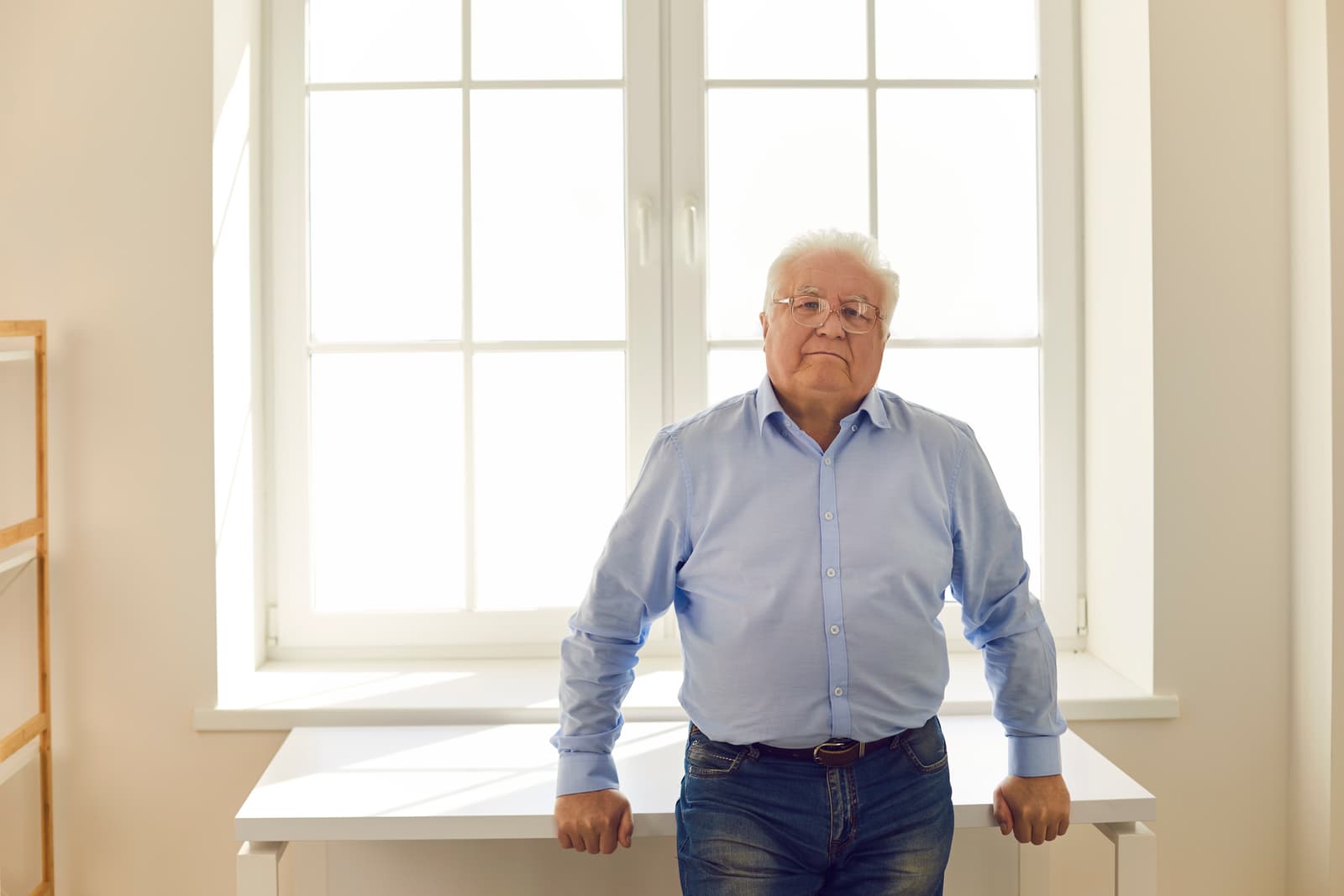 A white-haired consultant standing by an office window