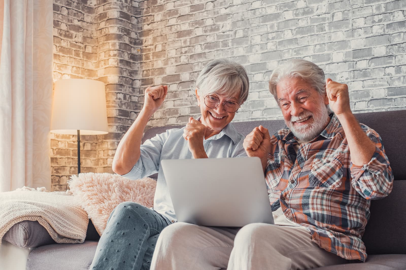 Two mature people delighted by what they see on screen